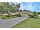 Suburban home with a well-manicured lawn and a long driveway leading to a two-car garage at 1310 Pup Fish Ln, Deland, FL 32724