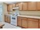 Well-lit kitchen featuring light wood cabinets, white appliances, and neutral countertops at 1310 Pup Fish Ln, Deland, FL 32724