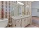 Bathroom featuring vanity, toilet, mirror, overhead lighting, and geometric patterned accent wall at 1411 N Beach St, Ormond Beach, FL 32174