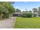 Well-maintained single-story home featuring a spacious front yard, mature landscaping, and a paved driveway leading to the garage at 1411 N Beach St, Ormond Beach, FL 32174