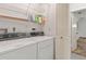 Functional laundry room featuring a side-by-side washer and dryer, wire shelving, and louvered door at 1411 N Beach St, Ormond Beach, FL 32174