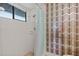 Ensuite walk-in shower with tile walls and geometric patterned accent wall at 1411 N Beach St, Ormond Beach, FL 32174