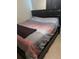 Cozy bedroom featuring a large bed with a striped comforter, tile flooring, and a dark headboard at 1556 Ferendina Dr, Deltona, FL 32725