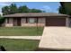 Charming single-story brick home featuring an attached garage, and a well-maintained front yard at 1556 Ferendina Dr, Deltona, FL 32725