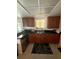 Well-lit kitchen featuring dark countertops, wood cabinets, and a view to the backyard through a large window at 1556 Ferendina Dr, Deltona, FL 32725