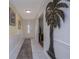 Inviting hallway with white tile flooring, decorative wall art, and a glimpse into the living spaces at 179 Ann Rustin S Dr, Ormond Beach, FL 32176