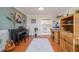 View of the living area showcasing hardwood floors, piano, and view into the kitchen at 179 Ann Rustin S Dr, Ormond Beach, FL 32176