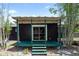 A view of the rear of the home with a lattice covered porch with green trim and privacy bamboo at 18 S Shell Rd, Debary, FL 32713