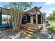 Back porch with wooden pergola, lighting, steps, and black painted brick facade at 18 S Shell Rd, Debary, FL 32713