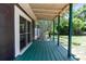 An exterior view of a green painted back porch with sliding glass doors to the home at 18 S Shell Rd, Debary, FL 32713