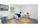 Cozy bedroom with wood-look floors, a white bed frame, soft lighting, and a window at 185 Brookside Dr, Port Orange, FL 32128