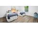 Cozy bedroom featuring two twin beds, soft lighting, and a window overlooking the yard at 185 Brookside Dr, Port Orange, FL 32128