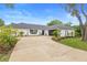 Charming single-story home with a well-manicured lawn and a long driveway leading to an attached garage at 185 Brookside Dr, Port Orange, FL 32128