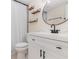 Updated bathroom featuring a modern vanity, round mirror, and stylish shelving at 1935 Conway Rd # A4, Orlando, FL 32812