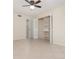 Bright bedroom featuring tile floors, ceiling fan, and a closet with bi-fold doors and built-in shelving at 1935 Conway Rd # A4, Orlando, FL 32812