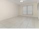 Spacious bedroom with tile flooring, large window, and closet with folding doors at 1935 Conway Rd # A4, Orlando, FL 32812