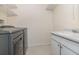 Bright laundry area features tile floors, wire shelving and utility sink at 1935 Conway Rd # A4, Orlando, FL 32812