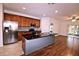 Open kitchen featuring stainless steel appliances, granite countertops, an island, and wood floors at 201 Walter Stevens Way, Deland, FL 32724