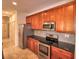 Kitchen featuring stainless steel appliances, granite countertops, tile backsplash, and wood cabinets at 201 Walter Stevens Way, Deland, FL 32724