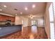 Living room with wood floors and recessed lighting open to the kitchen and a screened porch at 201 Walter Stevens Way, Deland, FL 32724