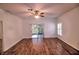 Bright living room with wood floors, ceiling fan, and sliding glass door to a balcony at 201 Walter Stevens Way, Deland, FL 32724
