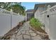 Backyard featuring a stone walkway and a white fence surrounding the yard at 202 W Chancery Ln, Deland, FL 32724