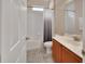 Bathroom features marble counters, wood cabinets, and a shower/tub combo with a blue shower curtain at 202 W Chancery Ln, Deland, FL 32724