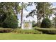 A community entrance with sign surrounded by trees and green landscaping at 202 W Chancery Ln, Deland, FL 32724