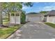 Two-car garage with spacious driveway, complemented by a white pergola, enhancing curb appeal at 202 W Chancery Ln, Deland, FL 32724