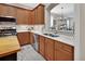 Featuring a sink with stainless appliances, wood cabinets, and mosaic backsplash at 202 W Chancery Ln, Deland, FL 32724