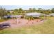 Community playground featuring a shade structure with swings, a slide, and other equipment for Gathering fun at 202 W Chancery Ln, Deland, FL 32724