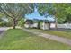 Yard featuring a white fence and trees bordering the sidewalk at 202 W Chancery Ln, Deland, FL 32724