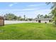 Large backyard features a lush green lawn, white fence, and back view of the house at 2127 3Rd Ave, Deland, FL 32724