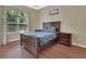 This bedroom is bright with a large window and beautiful wood flooring at 217 Lourdan Ct, Debary, FL 32713
