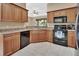 Charming kitchen features wood cabinets, black appliances and tile flooring at 217 Lourdan Ct, Debary, FL 32713