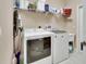 Well-equipped laundry room with washer, dryer, and storage shelves at 217 Lourdan Ct, Debary, FL 32713