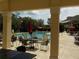 Community pool with tables, chairs, and umbrellas at 217 Lourdan Ct, Debary, FL 32713