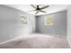 Bedroom featuring neutral carpet, gray walls, a ceiling fan, and two windows at 220 N Julia Ave, Deland, FL 32720