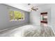 Bright bedroom featuring laminate floors, neutral walls, a ceiling fan, and a large window at 220 N Julia Ave, Deland, FL 32720