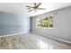 Spacious bedroom with gray walls, wood-look floors, and a large window overlooking the backyard at 220 N Julia Ave, Deland, FL 32720