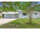 Charming single-story home with a well-maintained front lawn and attached garage at 220 N Julia Ave, Deland, FL 32720