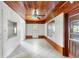 Bright living room featuring a wooden ceiling, white brick walls, tile flooring, and a doorway at 220 N Julia Ave, Deland, FL 32720