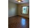 Comfortable bedroom with laminate flooring, a ceiling fan, and a large window providing natural light at 223 W Fiesta Key Loop, Deland, FL 32720