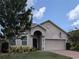 Charming single-story home with a well-manicured lawn and a welcoming two-car garage and American flag at 223 W Fiesta Key Loop, Deland, FL 32720