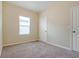 Clean bedroom features carpet, a window, and a door with neutral walls at 2241 Litchfield Loop, Deland, FL 32720