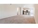 Spacious living room with neutral carpet, flowing into an open-concept kitchen with breakfast bar seating at 2241 Litchfield Loop, Deland, FL 32720
