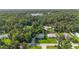 An aerial view showcasing the beautiful home nestled amongst lush trees and greenery near a serene lake at 2250 Davis Dr, New Smyrna Beach, FL 32168