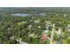 An aerial view of a neighborhood with mature trees and a glimpse of a serene lake at 2250 Davis Dr, New Smyrna Beach, FL 32168