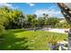 Expansive backyard with a fenced pool, lush lawn, and tropical landscaping creates a private oasis at 2250 Davis Dr, New Smyrna Beach, FL 32168