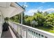 Relaxing covered balcony with white railings overlooks a backyard swimming pool and lush landscaping at 2250 Davis Dr, New Smyrna Beach, FL 32168